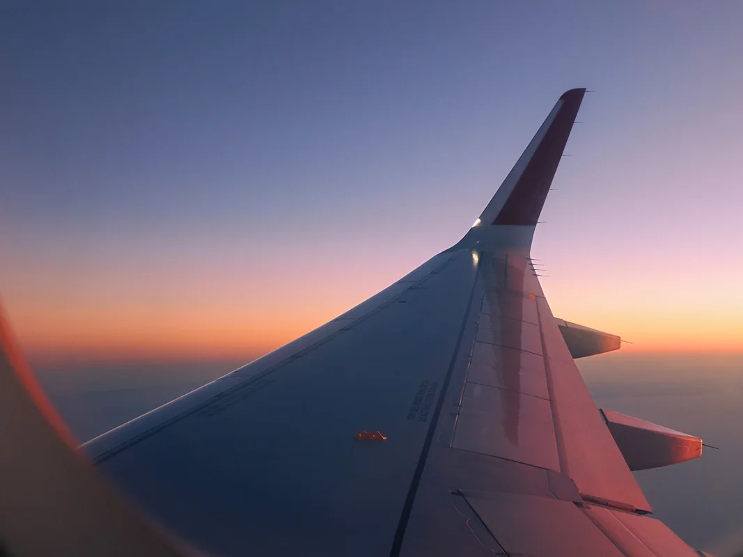 Sunset view from window over the wing of a commercial plane 