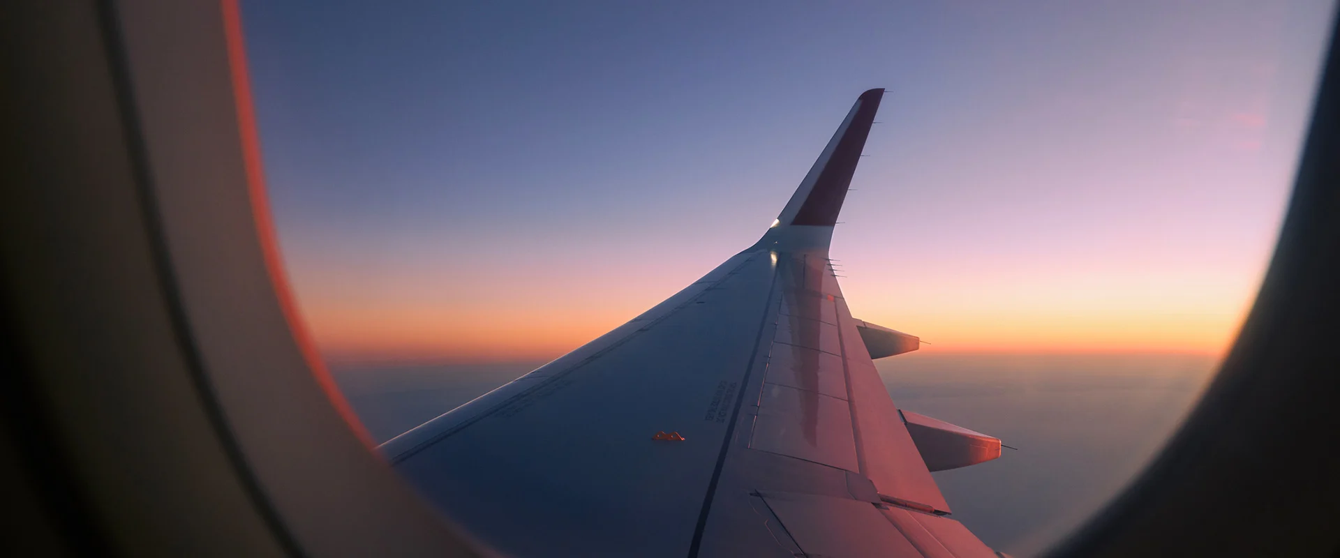 Sunset view from window over the wing of a commercial plane