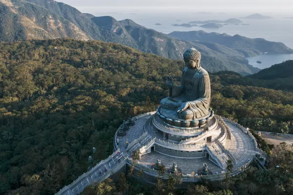 Hong Kong birds eye shot of infamous statue of the Big Buddha with beautiful mountain ranges in the background.