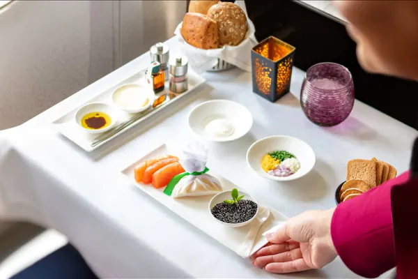 Qatar Airways business class spread of food supplied on white linen table cloth by airhost.