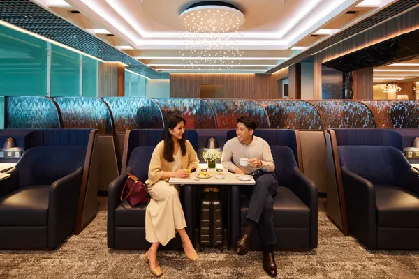 Singapore Airlines Changi Airport business class lounge with two passengers enjoying a coffee while waiting to board their flight.
