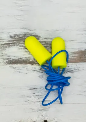 Different colors and shapes of earplugs lined up  on a table