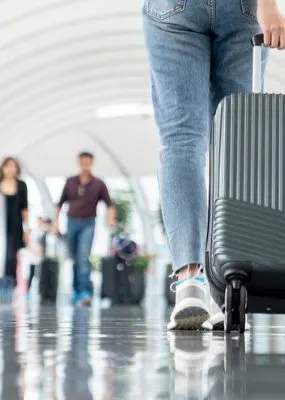 Image of a suitcase being wheeled through airport