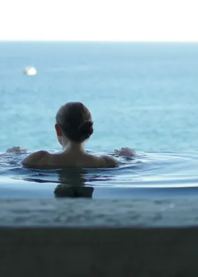 A woman relaxes in an infinity pool