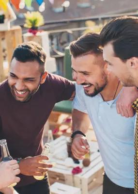 four men standing together and laughing on rooftop