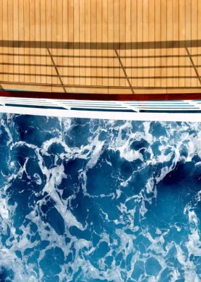 An aerial view to the stern of a cruise ship with disturbed water