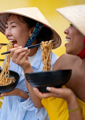 Travellers eating noodles while on a food tour in Asia