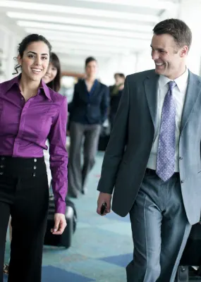 Airport with Business Team Walking, Pulling Luggage and Smiling
