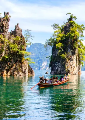 Clear blue waters surrounded by trees in Khao Sok National Park, Thailand.