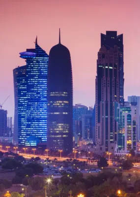 The Qatar skyline at dusk. The sky has turned a stunning deep maroon colour as the sun sets