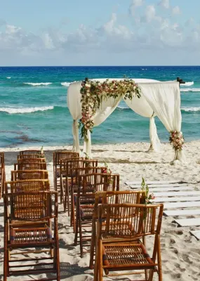 wedding on beach with wooden chairs 