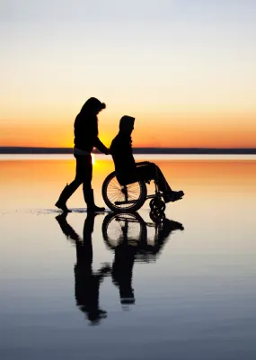 Wheelchair on beach at sunset