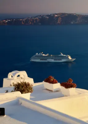 two cruise ships in sea with white buildings overlooking