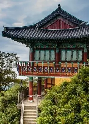Temple on top of cliff in south Korea with Mountains and sky in background. 