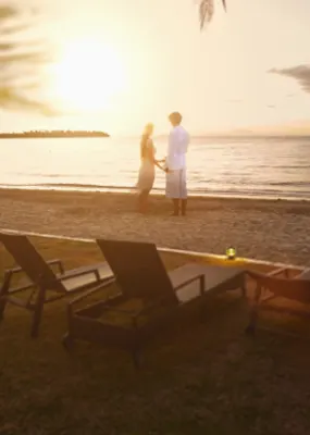Couple holding hands on the beach at sunset