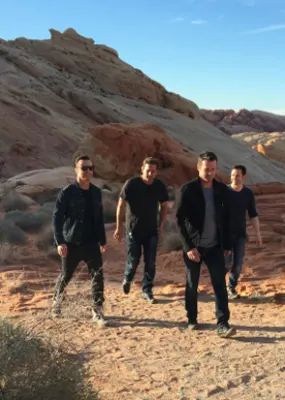 Four men in black walking in Nevada desert
