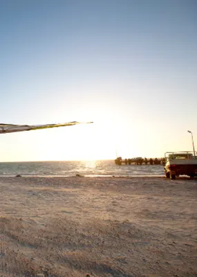 Person holding a wind surf on the beach at Lancelin