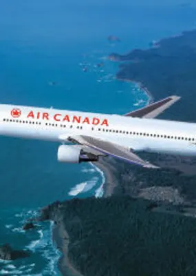 Air Canada plane flying over the ocean 