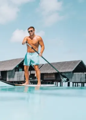 A couple paddle boarding in the ocean 