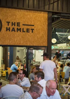 People sitting and eating around food trucks