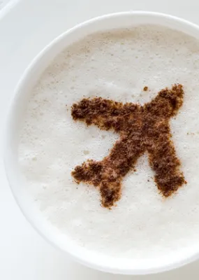 Croissants next to a latte art with airplane design