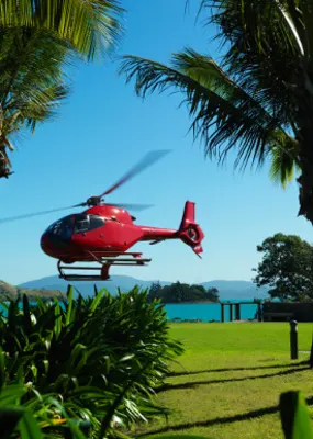 Helicopter landing on green grass at Hamilton Island 