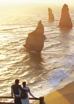 Couple enjoying the sunset on the mountain over the ocean shore