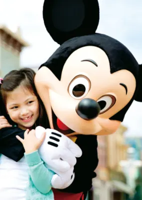 Mickey mouse hugging a young tourist