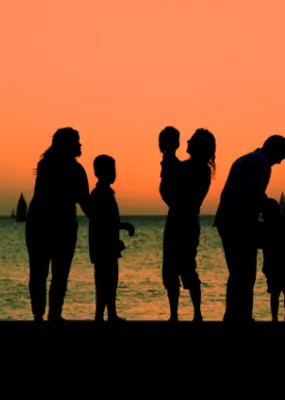 Silhouette of a family with the sunset and the ocean in the background