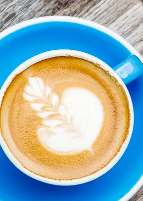 two blue cups of coffee with leaves latte art