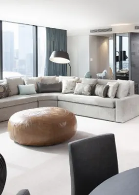 minimalistic living room with huge windows, L-shaped couch, and black dining table