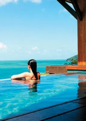 Woman enjoying infinity pool overlooking the ocean