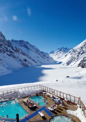 People lounge in a swimming pool beside a frozen lake in Portillo, Chile.
