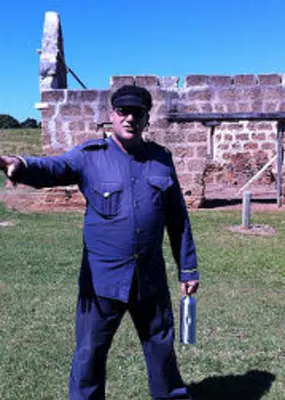Warden explaining the story of a historical structure behind him