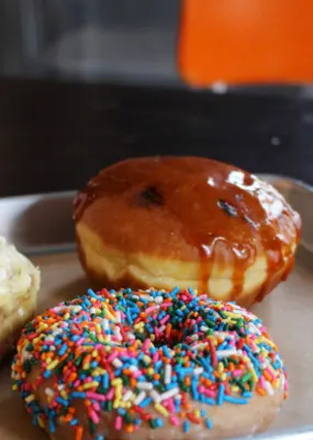 Mouth watering glazed doughnuts and a cup of coffee