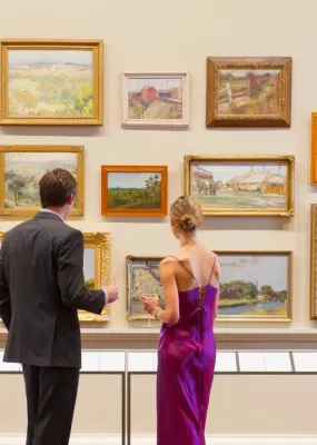 Man and woman in fancy eveningwear looking at art in a museum