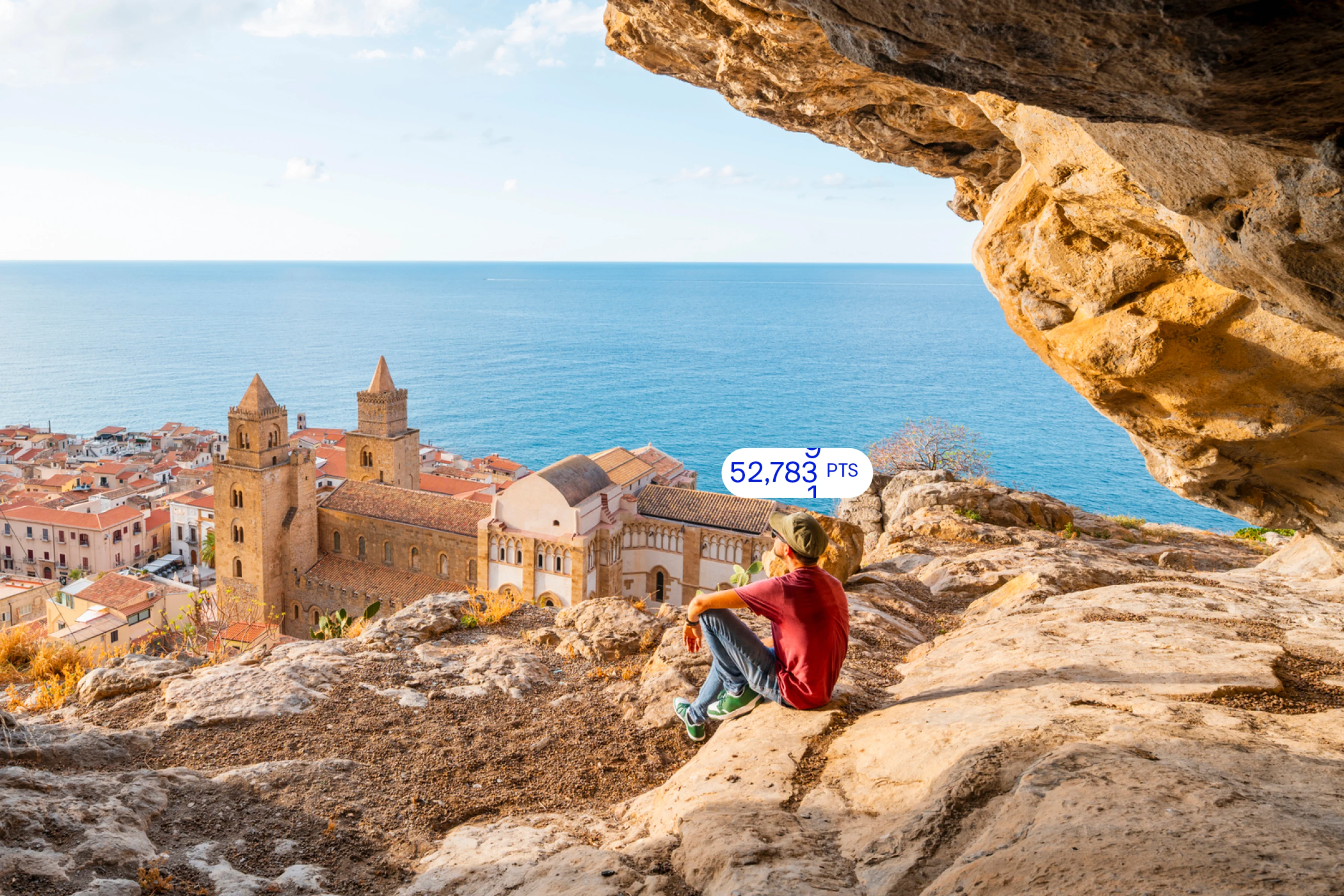 Person sitting on a rocky cliff overlooking the ocean