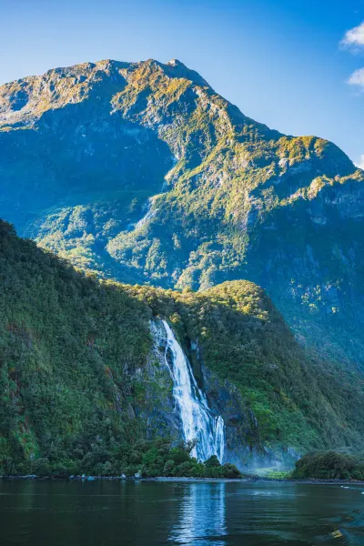 Waterfall in Fiordland National Park, luxury travel holiday, New Zealand