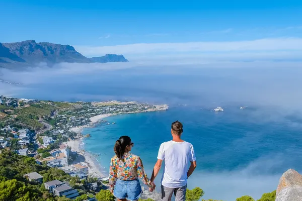 Two people standing on rock looking at ocean lookout