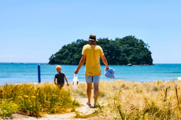 Father and son walking down pathway to beach