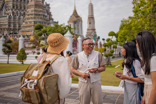 group of people talking to each other outside traditional building in bangkok