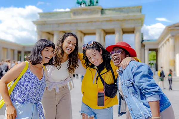 four girls with arms around each other smiling and laughing