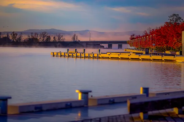 Piers lined by red trees at sunset