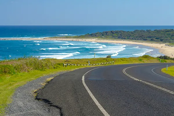 Stretch of highway with ocean waves in the background