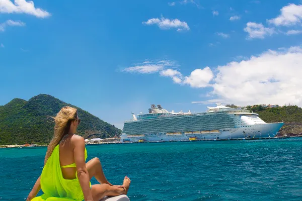 Lady sitting on floating kayak looking at cruise ship