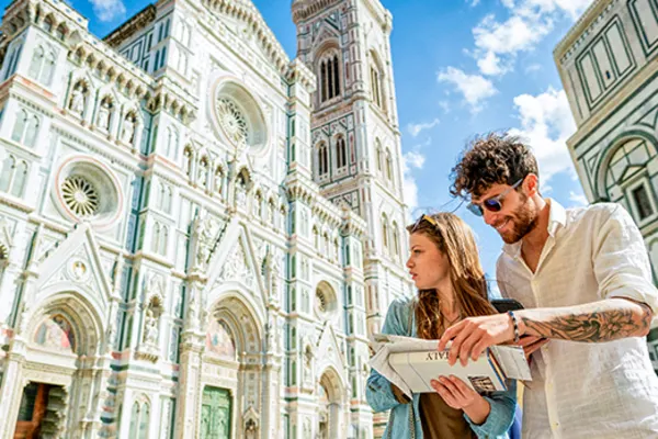 Couple looking at a map with a bright white cathedral in the background