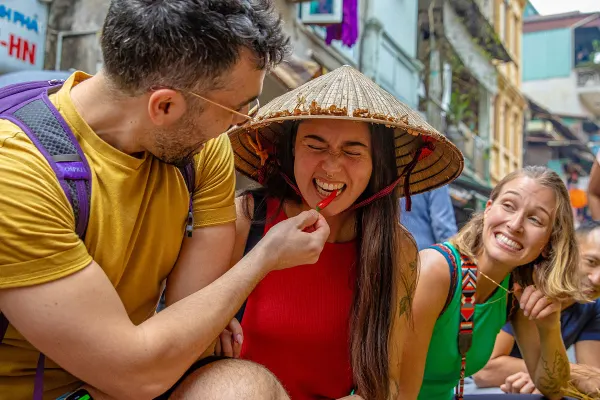 Friends eating red chilli's on the streets of Vietnam