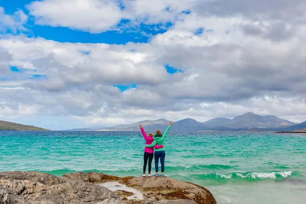 Two friends standing along coastline