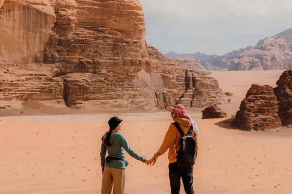 Couple holding hands looking out at a rocky desert