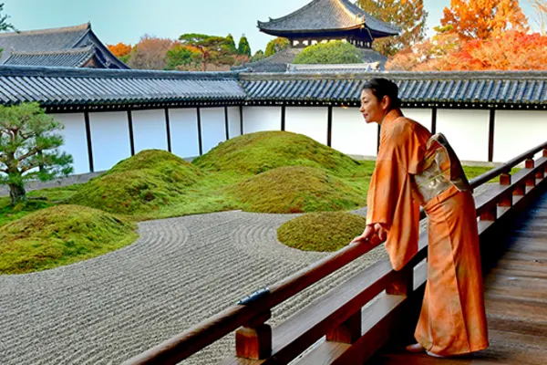 person leaning over balcony overlooking japanese backyard